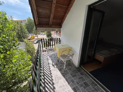 a balcony with a table and a fence at Lola in Prolomska Banja