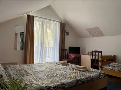a bedroom with a bed and a large window at Lola in Prolomska Banja