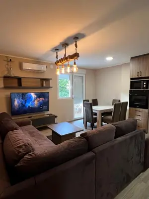 a living room with a couch and a dining room at Apartman Dašić in Jagodina