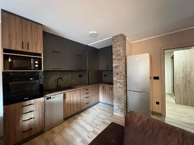 a kitchen with wooden cabinets and stainless steel appliances at Apartman Dašić in Jagodina