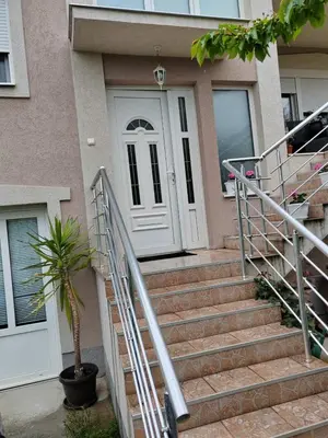 a house with a white door and stairs in front at Studio Petrović in Soko Banja