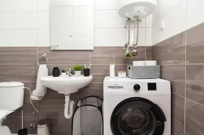 a bathroom with a washing machine and a sink at New Apartment in Vrnjačka Banja
