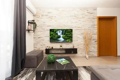 a living room with a tv on a brick wall at New Apartment in Vrnjačka Banja