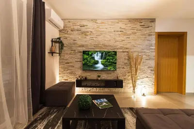 a living room with a tv on a brick wall at New Apartment in Vrnjačka Banja