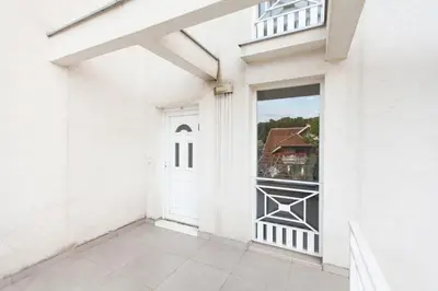 a white house with a door and a window at New Apartment in Vrnjačka Banja