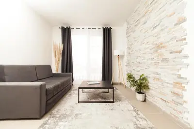 a living room with a couch and a brick wall at New Apartment in Vrnjačka Banja
