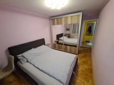 a bedroom with a bed and a large mirror at Stan na dan Braca in Niš