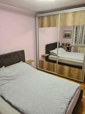 a bedroom with a mirror and a bed in it at Stan na dan Braca in Niš