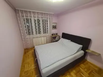 a small bedroom with a bed and a window at Stan na dan Braca in Niš