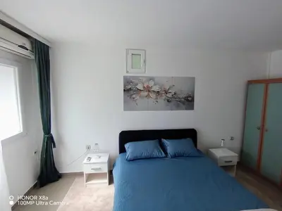 a bedroom with a blue bed and a painting on the wall at Apartman predah Vranje FREE PARKING U SKLOPU JEDINICE in Vranje