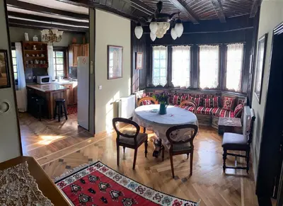 a living room with a table and a couch at Miletića čardak Ribarska Banja in Ribarska Banja