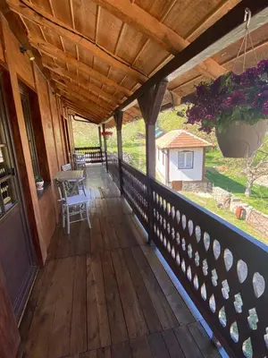a porch of a house with a wooden roof at Miletića čardak Ribarska Banja in Ribarska Banja