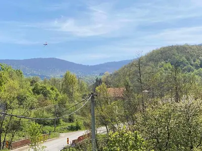 an airplane is flying over a road with trees at Miletića čardak Ribarska Banja in Ribarska Banja