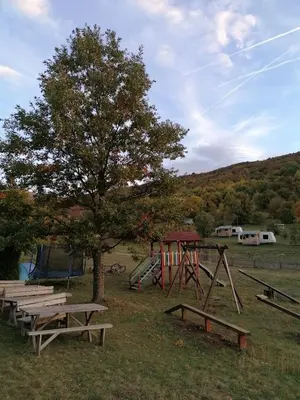 a park with benches and a tree and a playground at Tomiceva Koliba Rtanj 2 in Rtanj