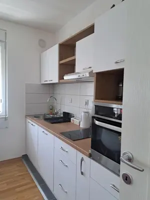 a kitchen with white cabinets and a stove top oven at Apartman Iva in Pirot