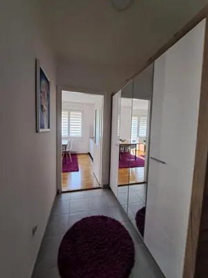 a hallway with a mirror and a room with a table at Apartman Iva in Pirot