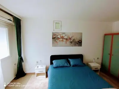 a bedroom with a blue bed and a painting on the wall at Predah in Vranje