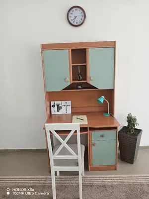 a desk with a chair and a clock on a wall at Predah in Vranje