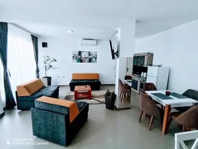 a living room with couches and a table and a kitchen at Predah in Vranje