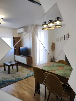 a room with a table and chairs and a television at Apartman Marla Vrnjacka Banja in Vrnjačka Banja