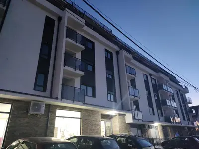 a large building with cars parked in front of it at Apartman Marla Vrnjacka Banja in Vrnjačka Banja