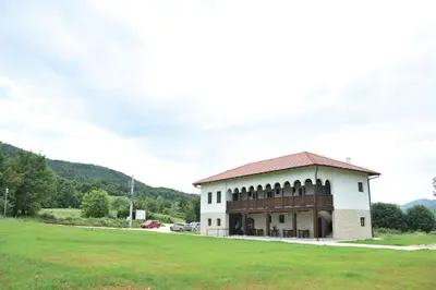 a building with a green field in front of it at Kod Bogdanovica in Vrtovac