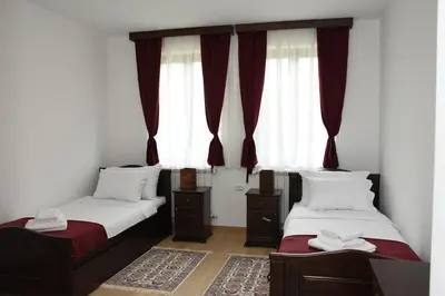 two beds in a room with red curtains at Kod Bogdanovica in Vrtovac