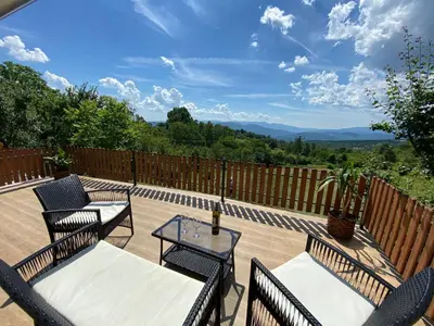 a patio with two tables and chairs and a fence at Vikvid in Nišor