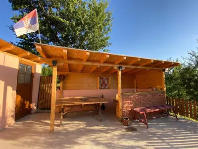 a wooden pavilion with a picnic table and a bench at Vikvid in Nišor