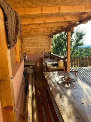 a porch of a wooden cabin with a wooden table at Vikvid in Nišor