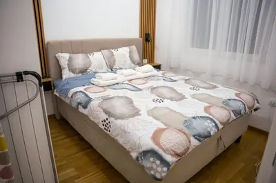 a bedroom with a bed with a blanket on it at Apartman North resort in Vrnjačka Banja