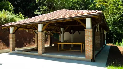 a pavilion with a picnic table in a park at Lesnik vacation home in Despotovac