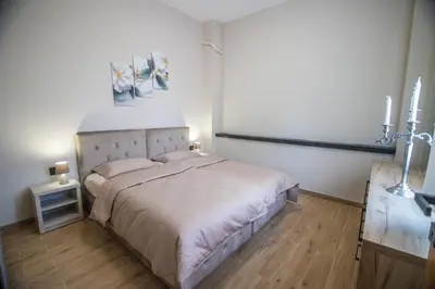 a bedroom with a bed and a table with a lamp at Apartmani Monero in Vrnjačka Banja