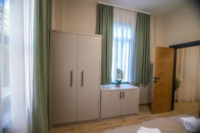 a bedroom with a large white cabinet and a window at Apartmani Monero in Vrnjačka Banja