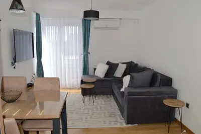 a living room with a black couch and a table at Apartman Ras in Vrnjačka Banja
