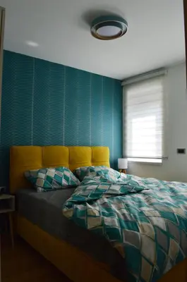 a bedroom with a bed with a blue wall at Apartman Ras in Vrnjačka Banja