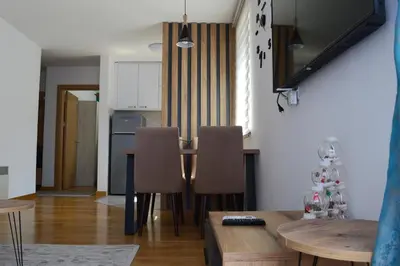 a kitchen and dining room with a table and chairs at Apartman Ras in Vrnjačka Banja