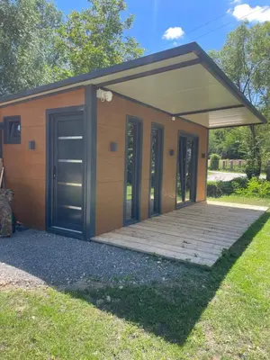 a small building with doors and a porch at Krupajsko vrelo in Milanovac