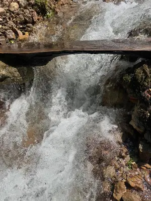a bridge over a river with water rushing over rocks at Krupajsko vrelo in Milanovac