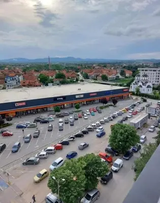 a parking lot full of cars and a train at leoben in Jagodina