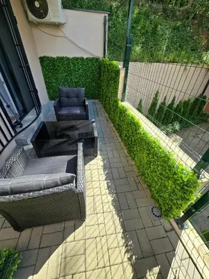 a patio with two chairs and a couch on a sidewalk at Apartman Sorelle in Vrnjačka Banja