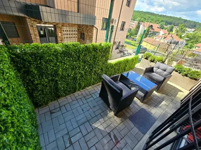 a balcony with two couches and a table and chairs at Apartman Sorelle in Vrnjačka Banja