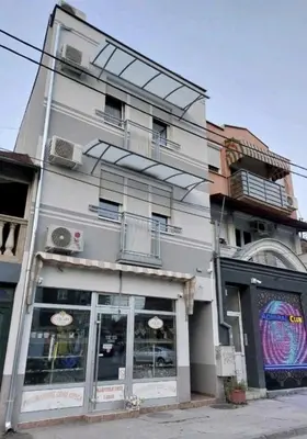 a white building with a balcony on the side of it at Apartments MIMOZA in Jagodina