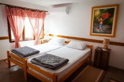 a bedroom with two beds and a painting on the wall at Porodična kuća Vitina Iža in Pirot