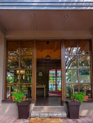 a store front with large windows and a clock at Restoran Lisine - Resavska pećina in Despotovac