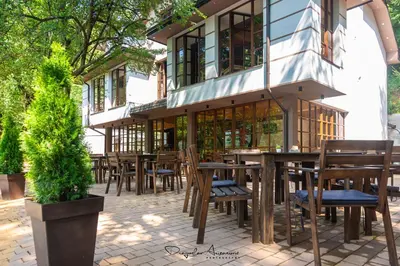 a patio with tables and chairs in front of a building at Restoran Lisine - Resavska pećina in Despotovac