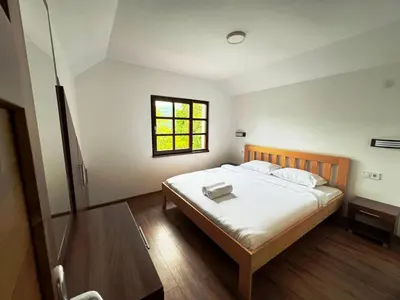 a bedroom with a large bed with a window at Restoran Lisine - Resavska pećina in Despotovac