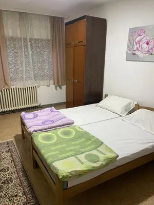 a bedroom with two beds and a dresser at Apartman Jošanička Banja in Jošanička Banja