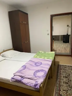 a room with two beds and a mirror and a mirror at Apartman Jošanička Banja in Jošanička Banja