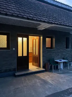 a door of a house with two chairs and a table at Apartman Jošanička Banja in Jošanička Banja